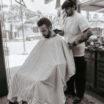 Barber inside the shop working on client's hair.