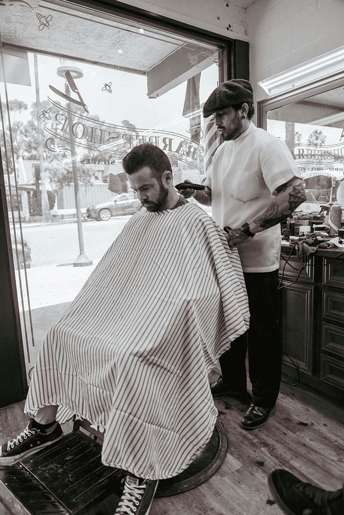 Barber inside the shop working on client's hair.